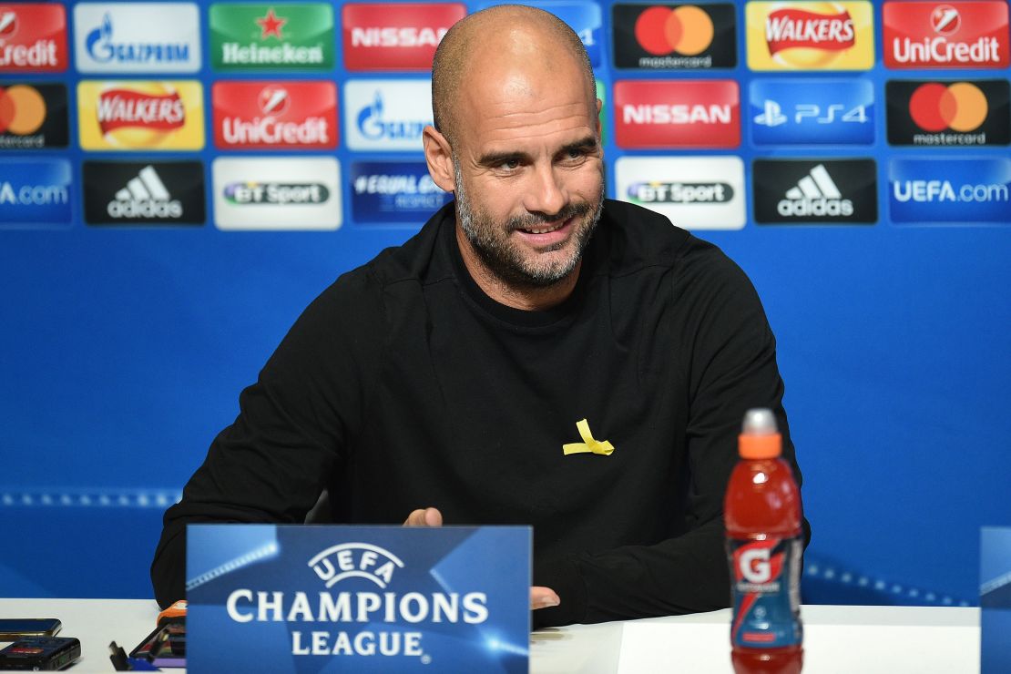 Manchester City's Spanish manager Pep Guardiola wears a yellow ribbon on his jumper, in support of those currently in detention in Catalonia, during a press conference.
