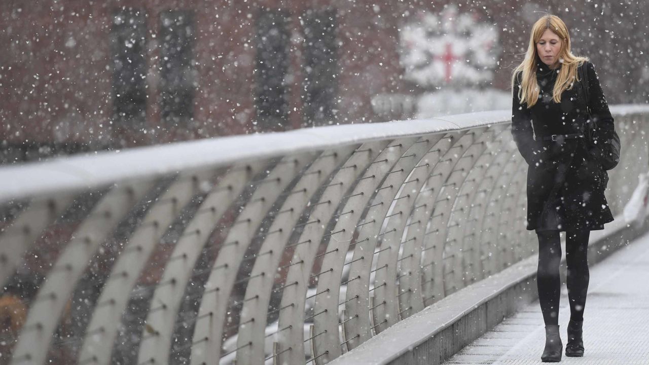 A commuter crosses London's Millennium Bridge over the Thames on Monday.