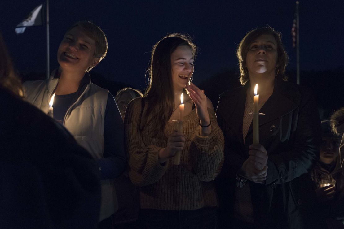 Susie Garrison, left, a teacher at Capital High School, student Amelia Engle from George Washington High School and Nitro High School teacher Kizmet Chandler take part in a candlelight rally in support of the statewide teacher walkout outside of the capitol building in Charleston, West Virginia, on Sunday.