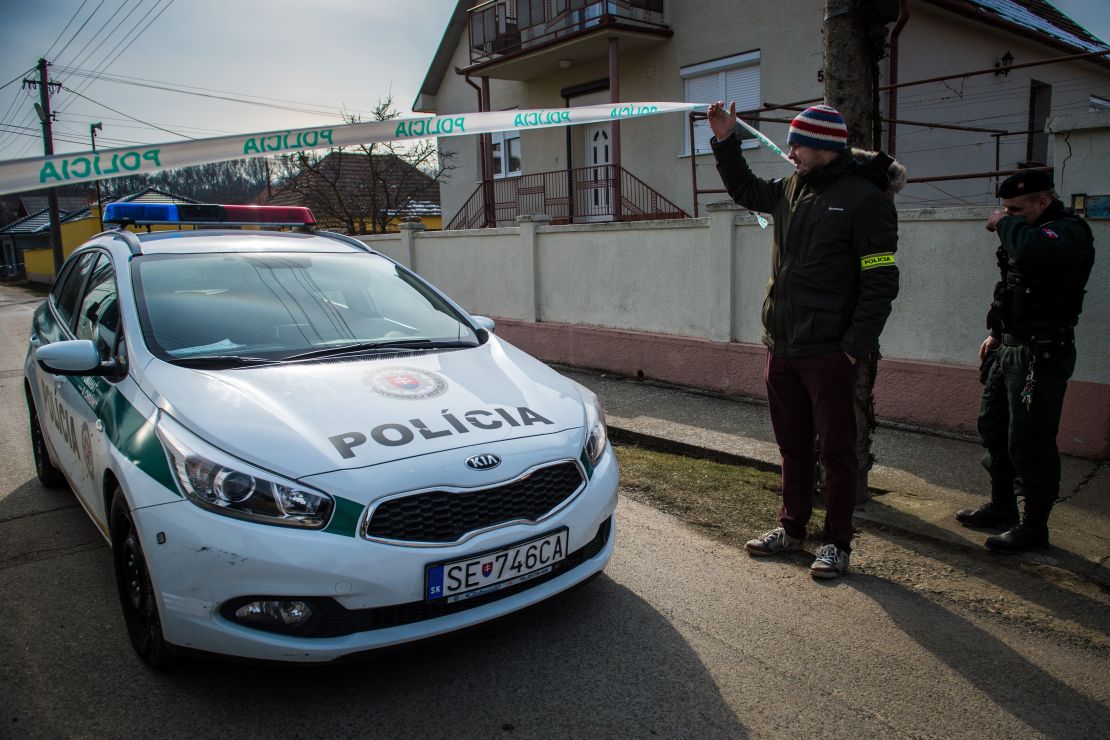 Policemen stand guard outside Jan Kuciak's apartment Monday.
