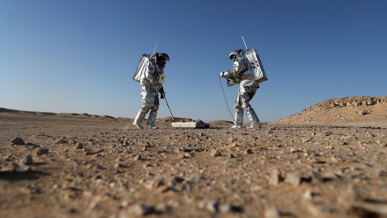 Members of the AMADEE-18 Mars simulation mission wear spacesuits while conducting scientific experiments in Oman's Dhofar desert.