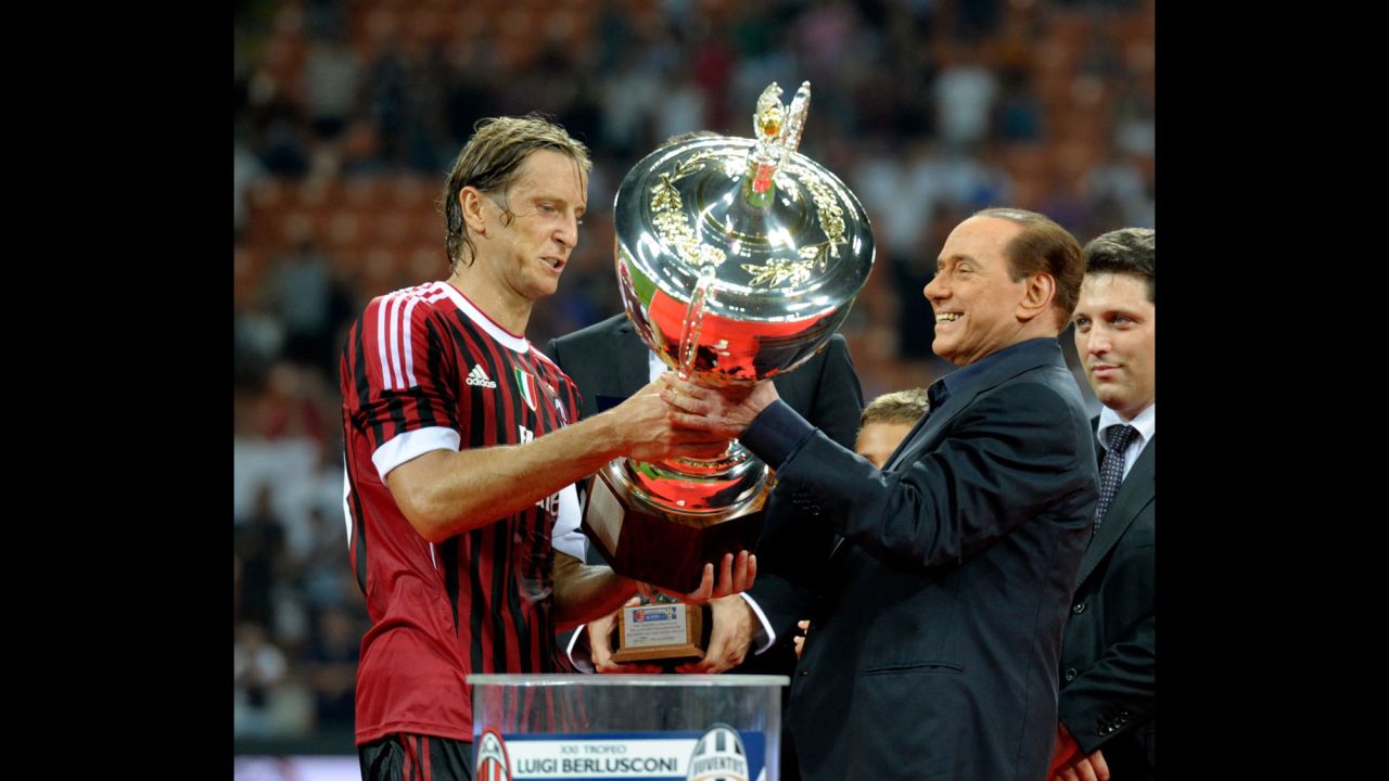 Berlusconi hands the Berlusconi Trophy to AC Milan's Massimo Ambrosini in August 2011. The trophy is awarded annually to the winner of a friendly football match in Milan.