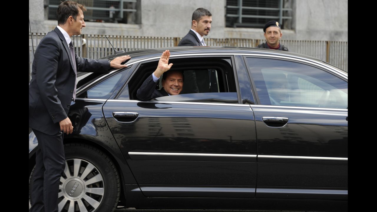 Berlusconi waves as he leaves a court in Milan in September 2011.