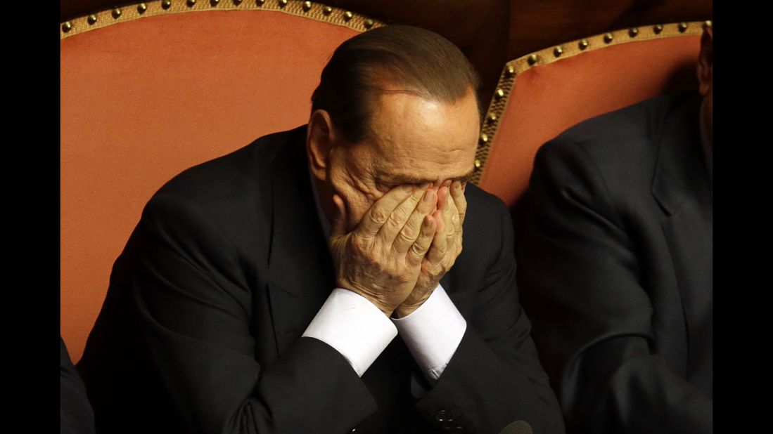 Berlusconi rubs his eyes after delivering a speech in Rome in October 2013. That month, Berlusconi was preliminarily indicted on allegations he bribed a senator to support his party in 2006. He would be convicted in 2015 and banned from holding public office for five years.