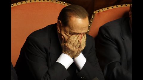 Berlusconi rubs his eyes after delivering a speech in Rome in October 2013. That month, Berlusconi was preliminarily indicted on allegations he bribed a senator to support his party in 2006. He would be convicted in 2015 and banned from holding public office for five years.