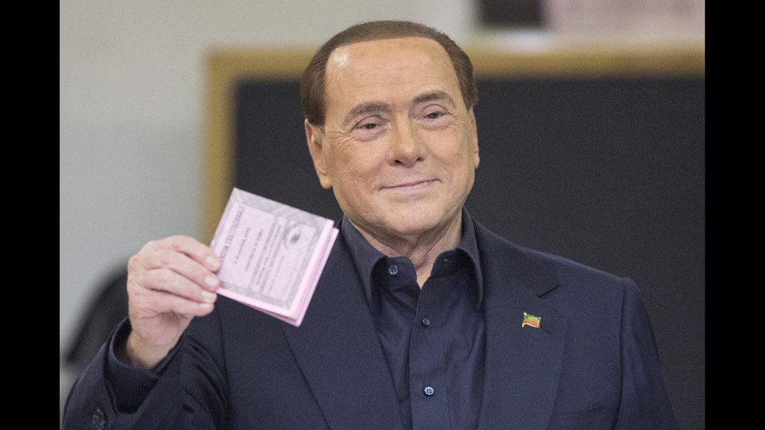 Berlusconi holds his ballot before casting his vote in the referendum on constitutional reform in December 2016.