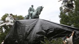 City workers drape a tarp over the statue of Confederate General Robert E. Lee in Emancipation park in Charlottesville, Va., Wednesday, Aug. 23, 2017.  The move to cover the statues is intended to symbolize the city's mourning for Heather Heyer, killed while protesting a white nationalist rally earlier this month.  (AP Photo/Steve Helber)