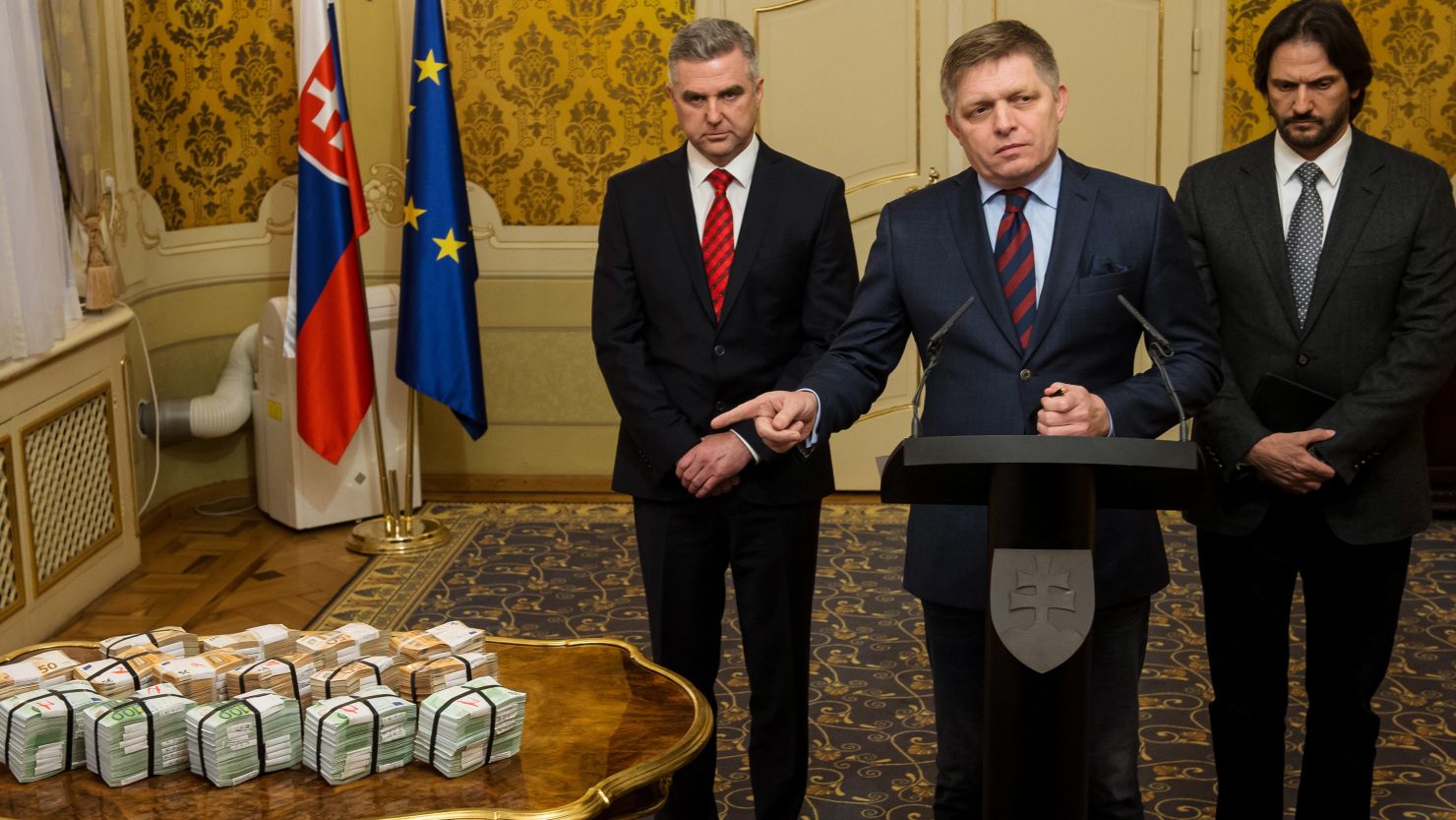 Slovak Prime Minister Robert Fico, center, points to the cash reward in a news briefing Tuesday.  