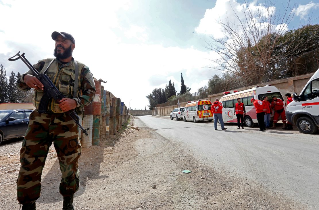 A Syrian troop stands guard near ambulances waiting to transport injured people at the Wafideen checkpoint on the outskirts of Damascus on Wednesday.