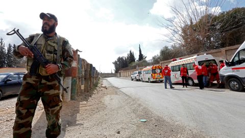 A Syrian troop stands guard near ambulances waiting to transport injured people at the Wafideen checkpoint on the outskirts of Damascus on Wednesday.