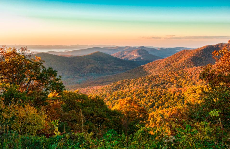 <strong>MOST POPULAR NATIONAL PARK SERVICE SITES: 1. Blue Ridge Parkway, North Carolina/Virginia:</strong> Blue Ridge Parkway meanders for 469 miles through two states, revealing gorgeous views of the Appalachian Highlands that vary by season. Autumn's changing foliage is evident in a sunrise view of the mountains in Brevard, North Carolina mountains near Asheville.