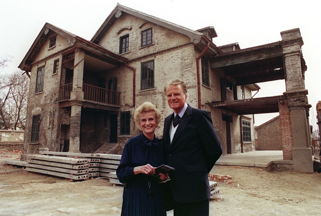 Billy Graham, the American evangelist and his wife Ruth smile, 19 April 1988 as they pose in front Ruth birthplace in Huaiyin, Jiangsu province, China.