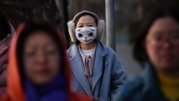 A woman wears a mask in Beijing