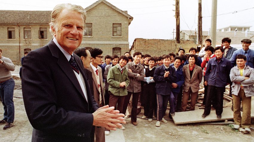 HUAIYIN, CHINA:  Billy Graham (L), the American evangelist, addresses Chinese faithful 20 April 1988 in front of his wife Ruth birthplace in Huaiyin, Jiangsu province, China. Graham, (son of a dairy farmer, born in 1918 in Charlotte, NC), attended Florida Bible Institute and was ordained a Southern Baptist minister in 1939 and quickly gained a reputation as a preacher. During the 1950s he conducted a series of highly organized revivalist campaigns in the USA and UK, and later in South America, the USSR and Western Europe. (Photo credit should read JOHN GIANNINI/AFP/Getty Images)