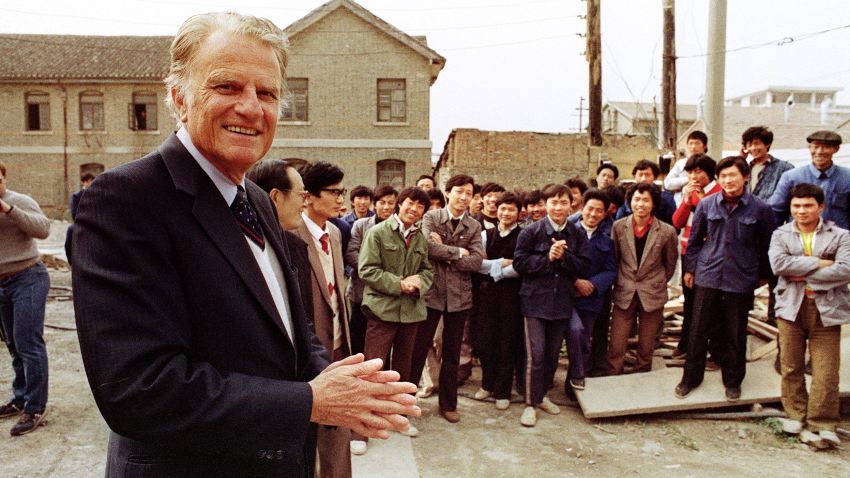 HUAIYIN, CHINA: Billy Graham (L), the American evangelist, addresses Chinese faithful 20 April 1988 in front of his wife Ruth birthplace in Huaiyin, Jiangsu province, China. Graham, (son of a dairy farmer, born in 1918 in Charlotte, NC), attended Florida Bible Institute and was ordained a Southern Baptist minister in 1939 and quickly gained a reputation as a preacher. During the 1950s he conducted a series of highly organized revivalist campaigns in the USA and UK, and later in South America, the USSR and Western Europe. (Photo credit should read JOHN GIANNINI/AFP/Getty Images)