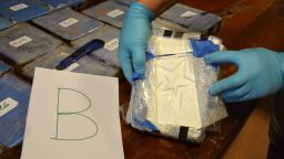 In this photo taken on Dec. 14, 2016, and released on Feb. 22, 2018 by the Argentine Security Ministry, a police officer shows a package of cocaine that with a star sign, that was found in an annex building of the Russian embassy in Buenos Aires, Argentina. A Russian diplomatic official and an Argentine police officer are among those arrested after authorities seized the cocaine shipment of 860 pounds (389 kilograms) at the Russian embassy in Buenos Aires that prompted them to launch a yearlong joint investigation to dismantle a drug ring, the government said. (Argentine Security Ministry via AP)