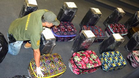 A police officer guards the suitcases found carrying the drugs.