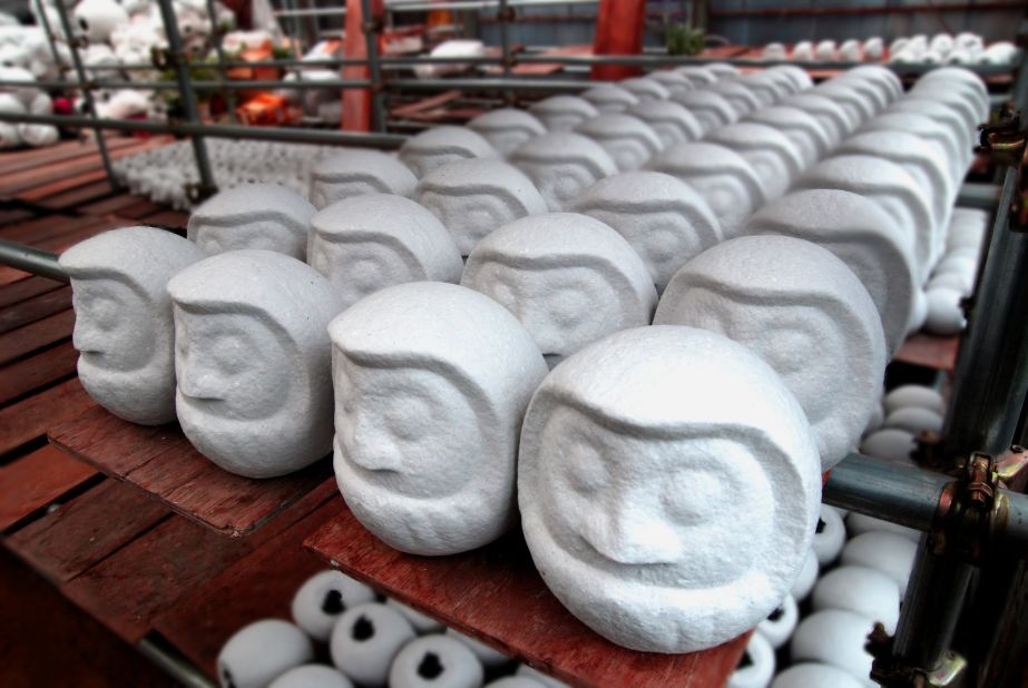 Daruma doll artists give the dolls white base before painting them red. 