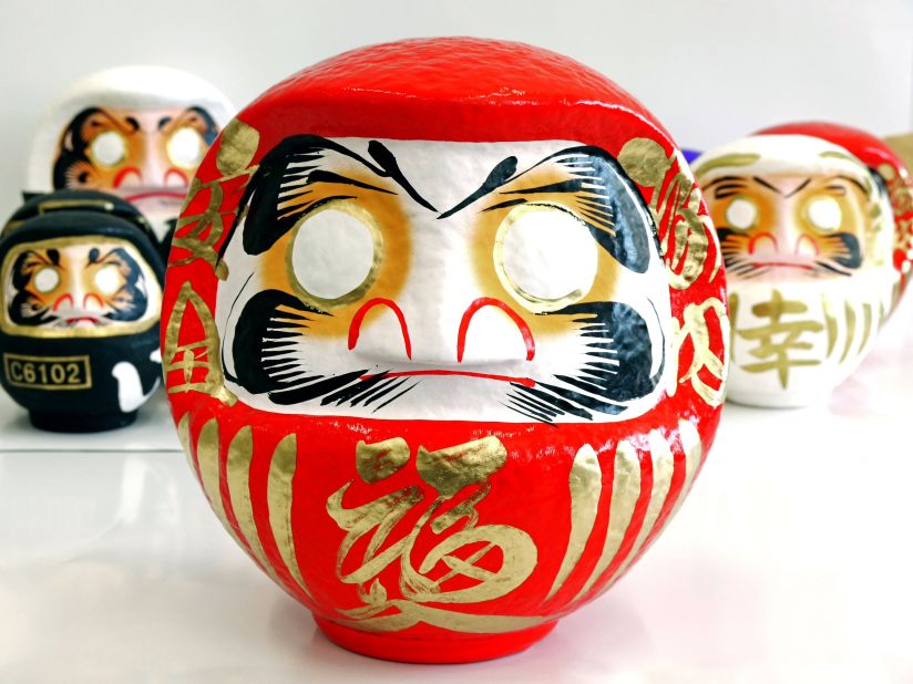 The Daruma dolls' faces are typically decorated using two animals associated with good luck and longevity -- cranes and turtles. The former appear as eyebrows while two of the latter form a beard. 