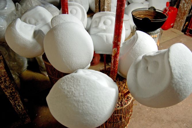 Daruma that have been dipped in liquid paper-mache are left to dry.