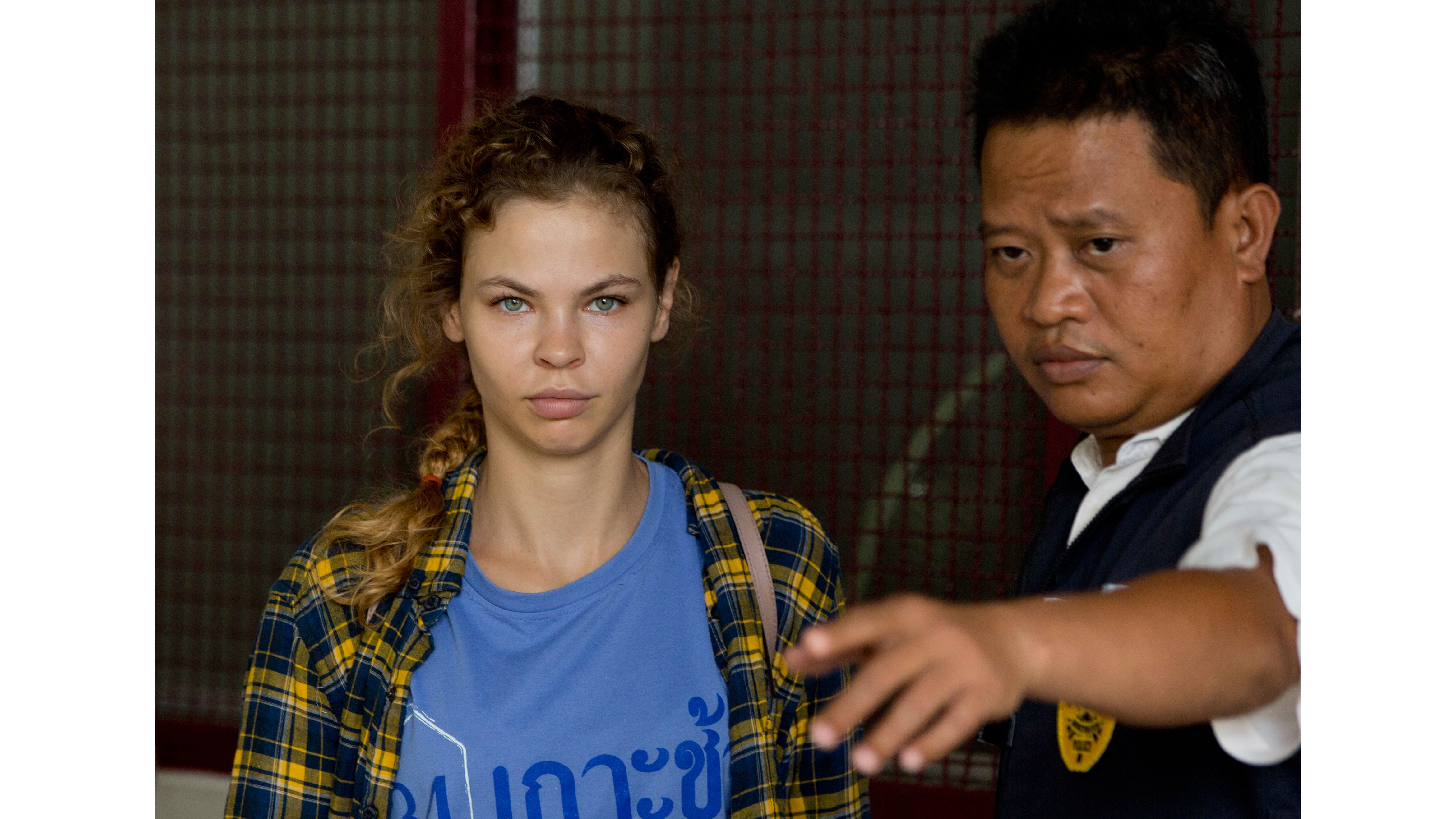 A police officer escorts Anastasia Vashukevich from a detention center in Pattaya, south of Bangkok, Thailand, Wednesday, Feb. 28, 2018.