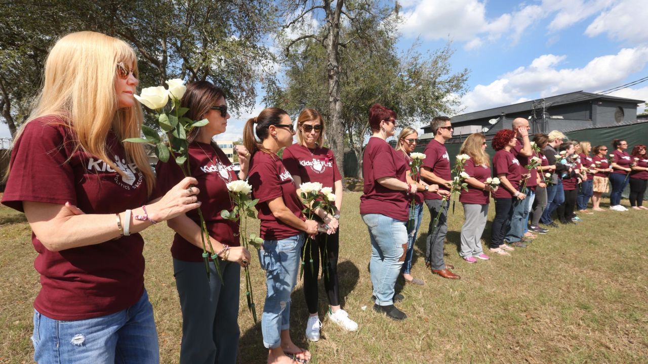 Parkland parents, students and community members hold flowers at the Pulse nightclub attack site.