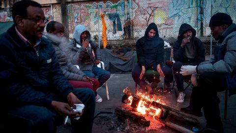 Migrants warm up around a fire at a makeshift camp in Rome in February.