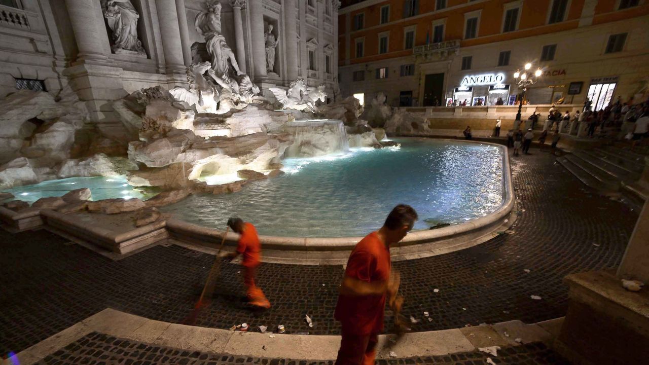 A worker with the municipal rubbish collection company cleans the floors of the Trevi Fountain in August 2016.