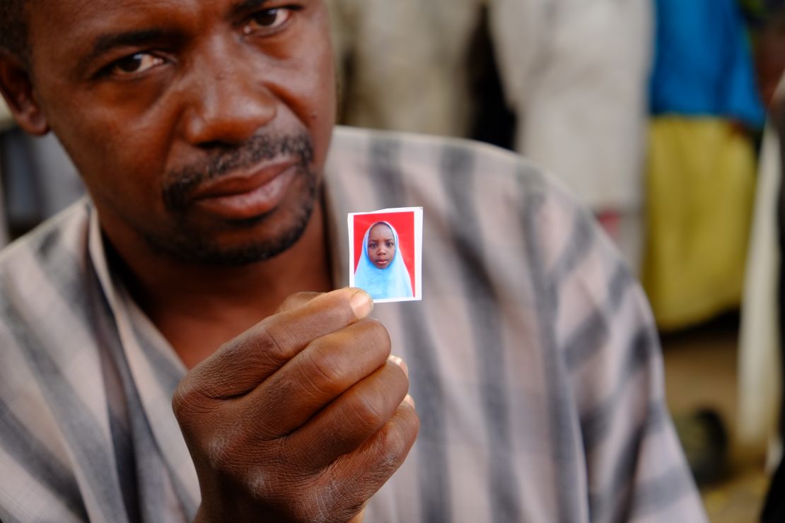 Alhaji Garba Tela shows a photograph of his missing daughter, Zainab.