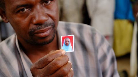 Alhaji Garba Tela shows a photograph of his missing daughter, Zainab.