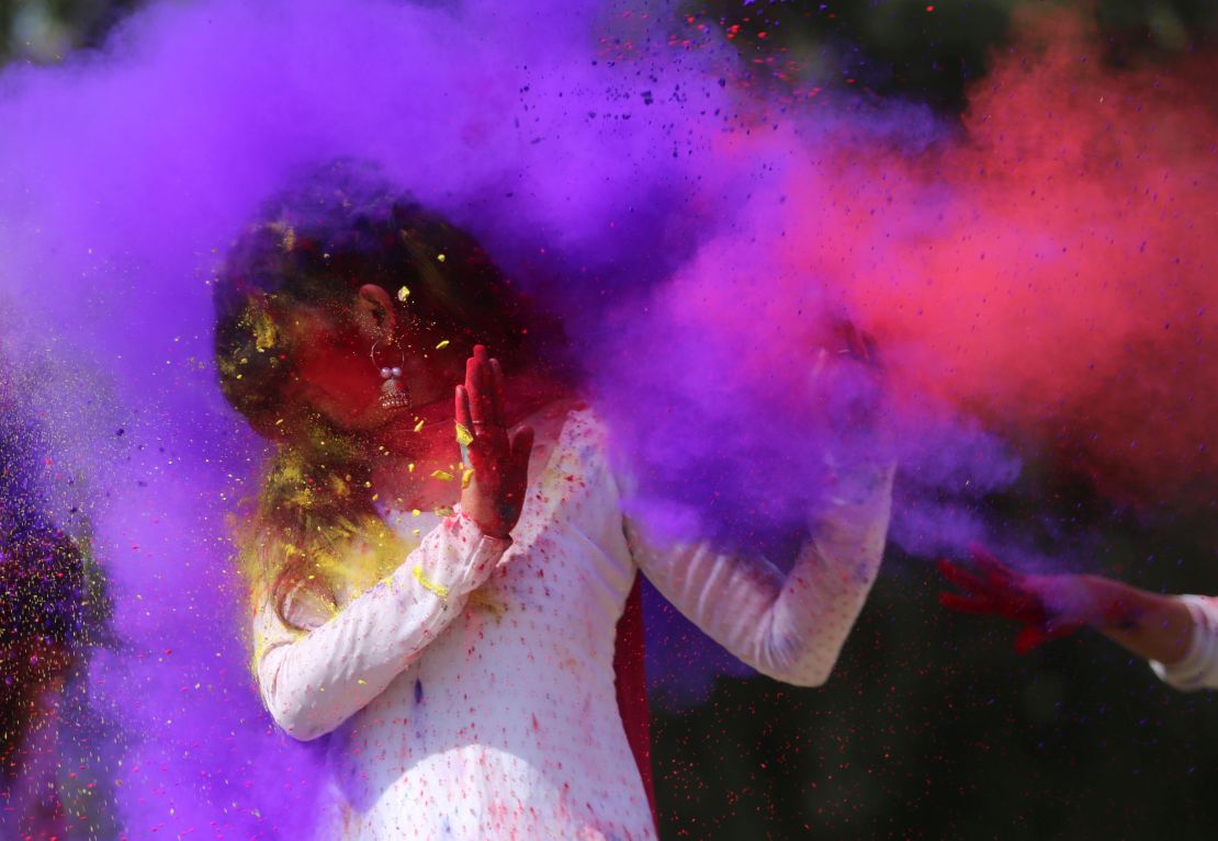 Indian college girls throw colored powder to one another during Holi festival celebrations in Bhopal in 2018. 
