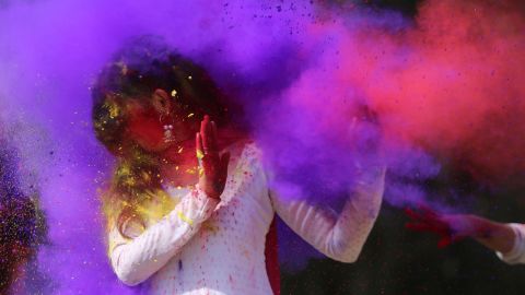 Indian college girls throw colored powder to one another during Holi festival celebrations in Bhopal on February 28, 2018. 
