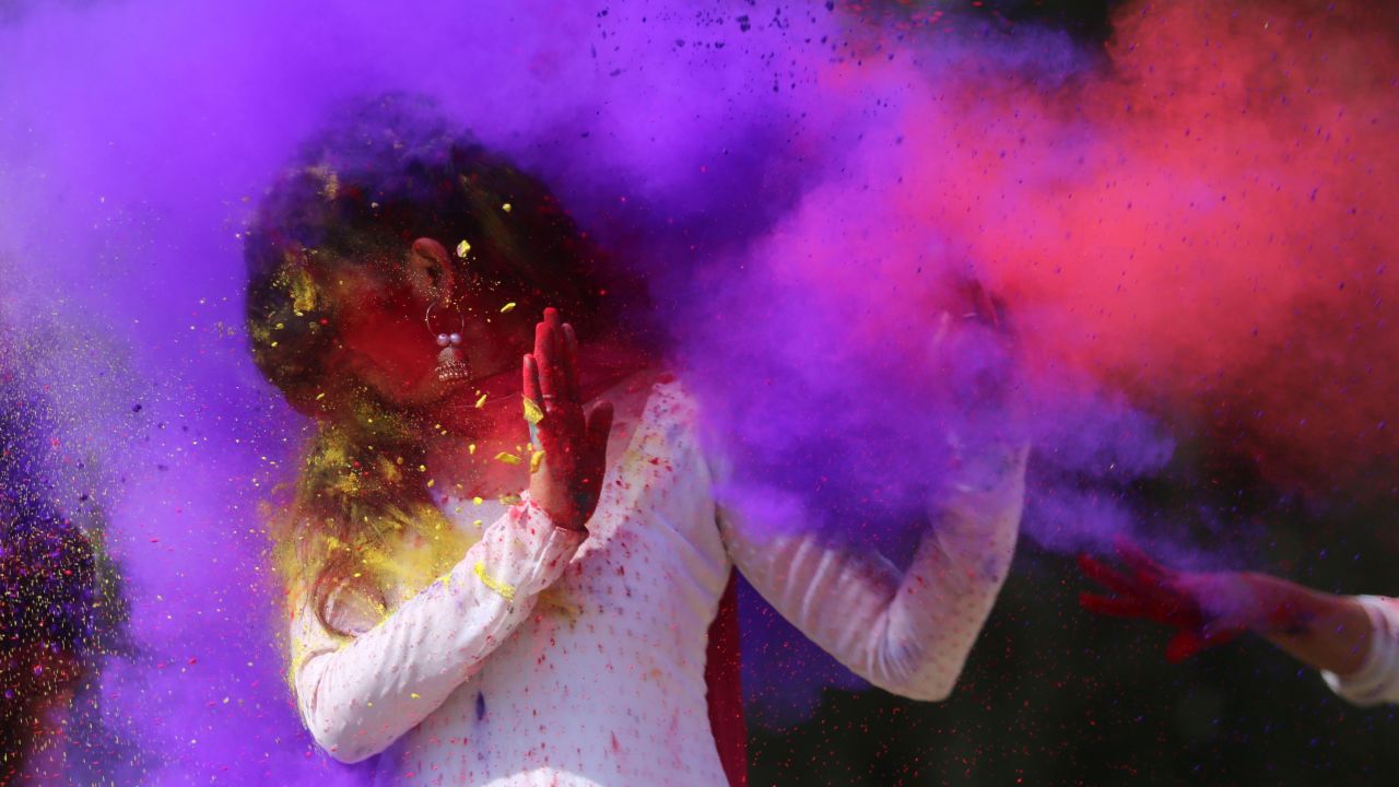 Indian college girls throw colored powder to one another during Holi festival celebrations in Bhopal on February 28, 2018.
