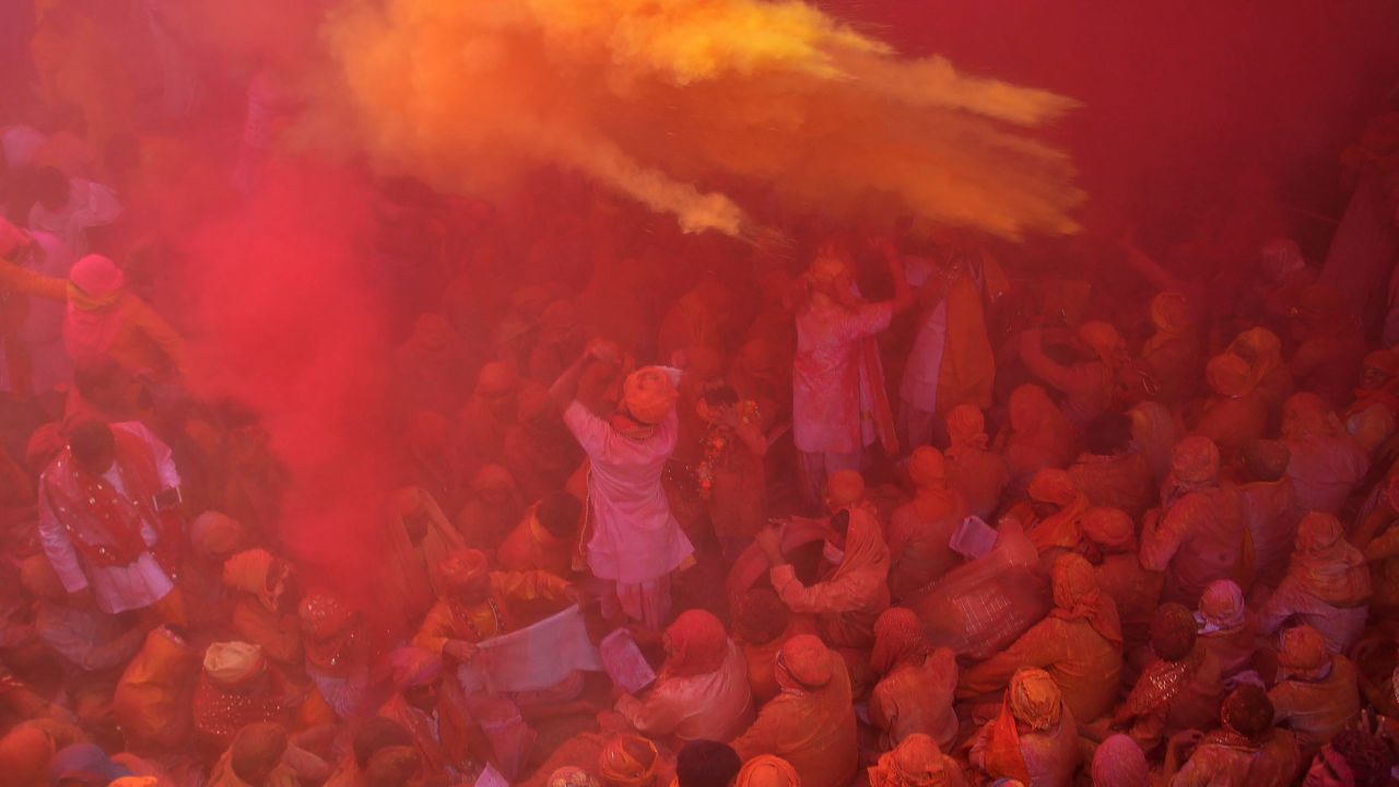 Indian Hindu devotees throw colored powder during celebration of Holi Festival at Sriji temple in Barsana in the northern Indian state of Uttar Pradesh on February 23, 2018.