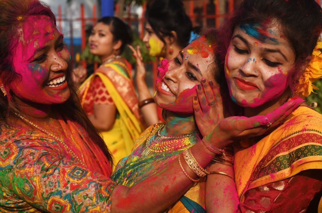 Indian students smear colored powder during an event to celebrate the Hindu festival of Holi in Kolkata on February 26, 2018.

