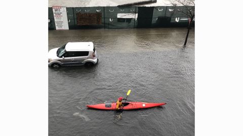 A kayaker paddles down a flooded street in Boston on Friday.