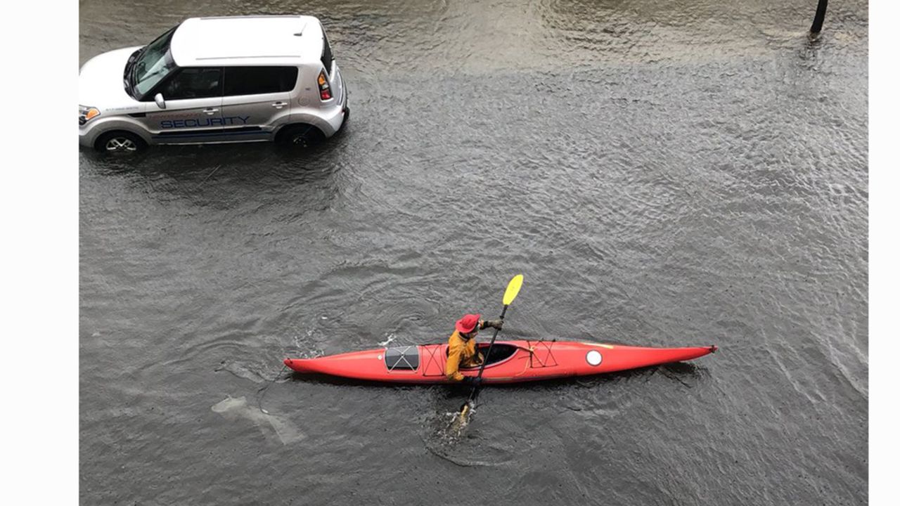 A kayaker paddles down a flooded street in Boston on Friday.
