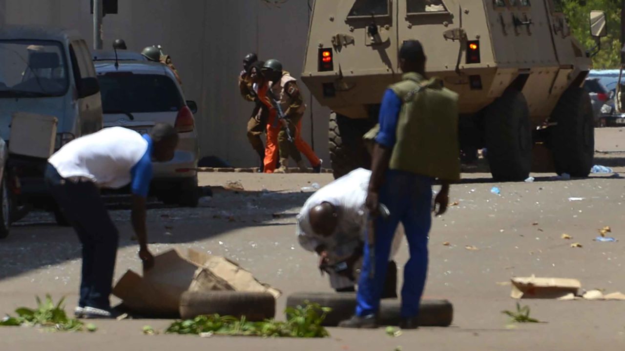 Bystanders look on as security personnel move beside an armoured personnel carrier in Ouagadougou on Friday.