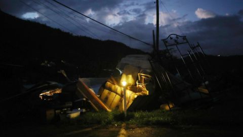 A donated solar lamp in a driveway illuminates storm debris still waiting to be collected last December.