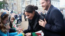 CARDIFF, WALES - JANUARY 18:  Meghan Markle writes a note for 10 year old Caitlin Clarke from Marlborough Primary School as Prince Harry looks on during a walkabout at Cardiff Castle on January 18, 2018 in Cardiff, Wales.  (Photo by Chris Jackson/Getty Images)