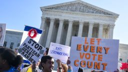 People hold signs during a rally to call for "An End to Partisan Gerrymandering" at the Supreme Court of the United States on October 3, 2017 in Washington, DC.  