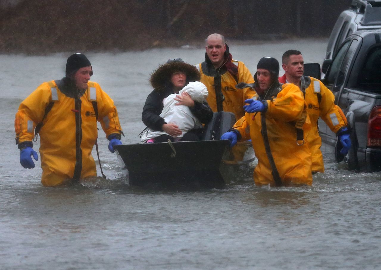Rescuers help a mother and child leave their Quincy, Massachusetts, home by boat on March 2.