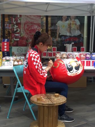 Chihiro Nakata, a fifth generation Daruma craftsman, puts the finishing touches on a daruma doll. 