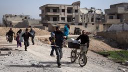 Syrians flee their homes with their belongings in the town of Beit Sawa in Syria's besieged eastern Ghouta region on March 4, 2018, following reported air strikes.
Syria's regime seized control of over a quarter of rebel-held Eastern Ghouta on the edge of Damascus after two weeks of devastating bombardment, sending hundreds of civilians into flight, the Syrian Observatory for Human Rights said.
