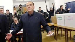 Italian former premier and leader of Forza Italia (Let's Go Italy) party Silvio Berlusconi listens to reporters at a polling station in Milan, Italy, Sunday, March 4, 2018. More than 46 million Italians were voting Sunday in a general election that is being closely watched to determine if Italy would succumb to the populist, anti-establishment and far-right sentiment that has swept through much of Europe in recent years. (AP Photo/Antonio Calanni)