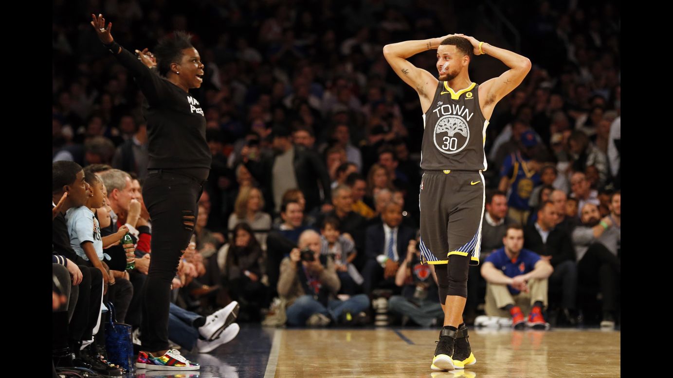 Golden State guard Stephen Curry looks at comedian Leslie Jones as she reacts during an NBA game in New York on Monday, February 26.