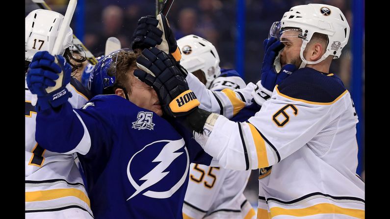 Buffalo's Marco Scandella, right, exchanges a "face wash" with Tampa Bay's Yanni Gourde during an NHL game on Wednesday, February 28.