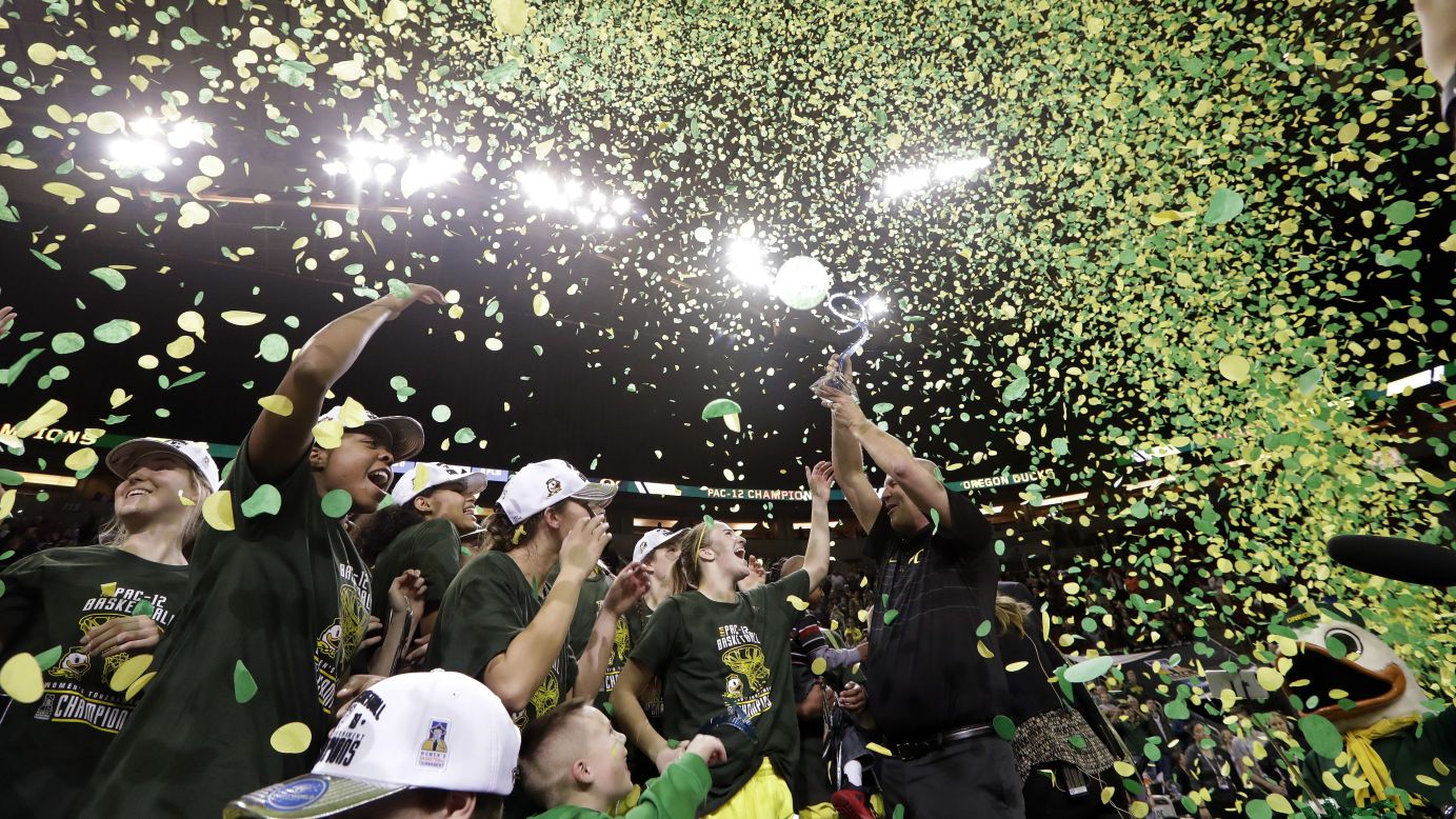 Kelly Graves, head coach of the women's basketball team from Oregon, lifts the trophy after the Ducks won the Pac-12 Conference tournament on Sunday, March 4.