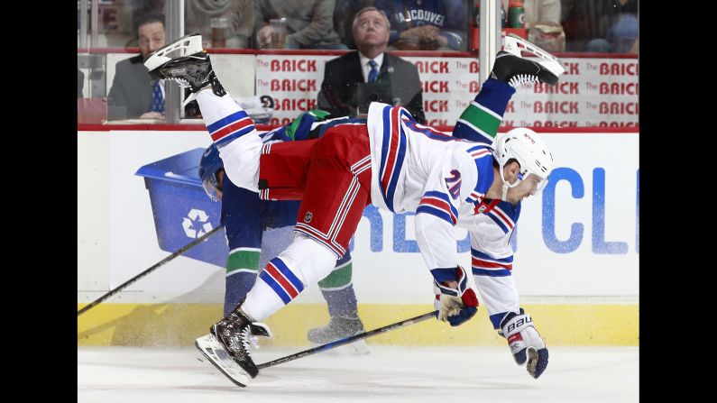 Chris Kreider, foreground, is checked by Alexander Edler during an NHL game in Vancouver, British Columbia, on Wednesday, February 28.