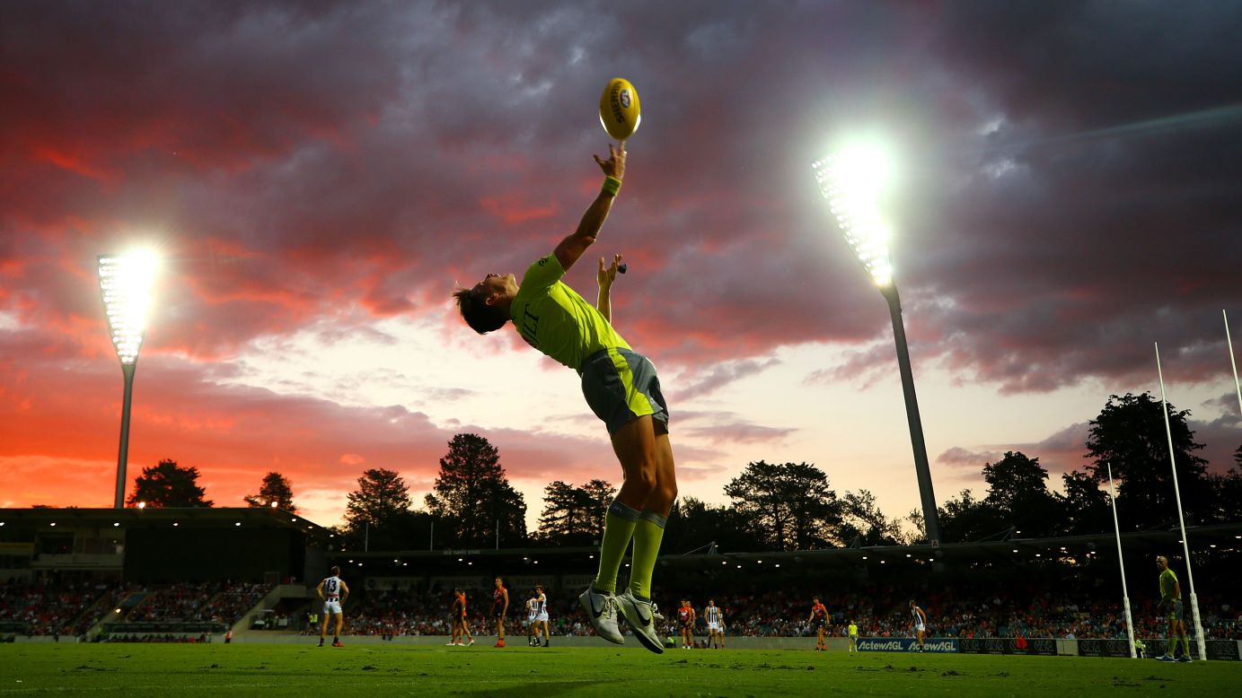 An Australian Football League umpire throws the ball in during a match in Canberra on Thursday, March 1.